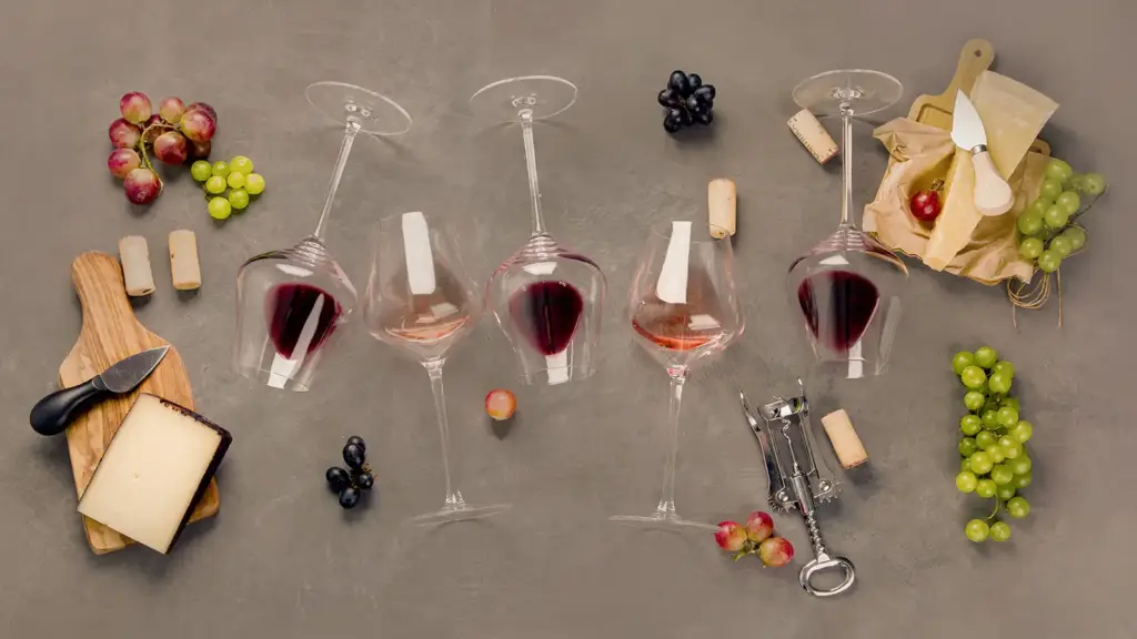 A spread of wine glasses mixed with cheese platters and bunches of grapes